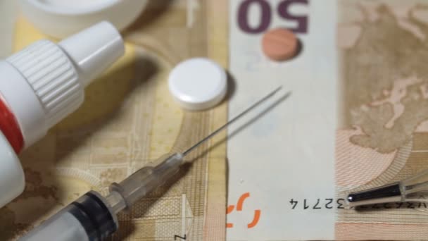スプレー、注射器、薬とお金の背景上の温度計. — ストック動画