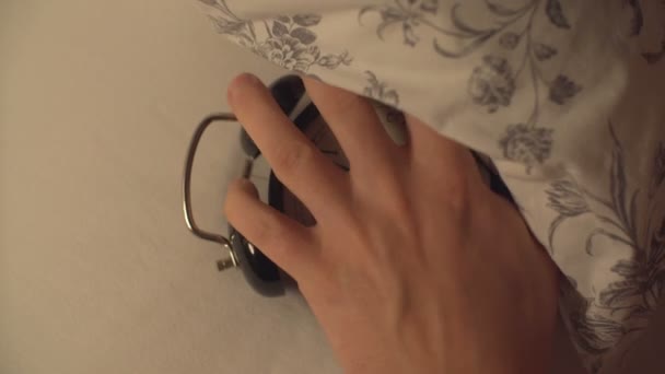 Mann schaltet Wecker am Bett aus — Stockvideo