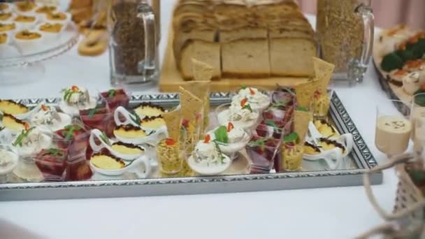 Schön dekorierter Catering-Banketttisch mit verschiedenen Snacks und Vorspeisen auf Firmengeburtstagsfeier oder Hochzeitsfeier. — Stockvideo