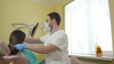 Erkek diş hekimi diş Kliniği bir kadın hastada incelemek hazırlar, göğüs Steril bez koyar.