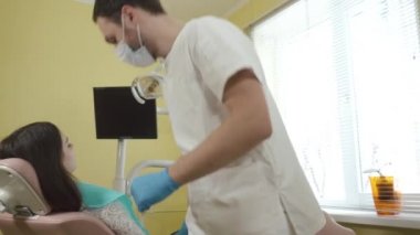 Erkek diş hekimi düzeltilmesi için diş Kliniği bir kadın hastada hazırlar..