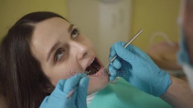 Ağız ve diş incelenmesi. Yakın çekim oral check-up sırasında hasta genç kız açık ağız.