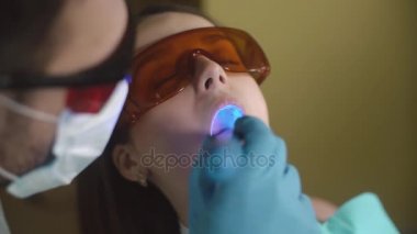 Diş Uv ışık cihazları ile muamele yakın çekim, kadın hasta. Diş office.