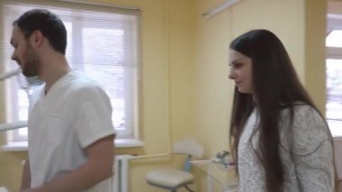 Diş ofisi. Bir diş hekimi diş sandalye bir sağlık kontrolü için bir hasta davet ediyor.