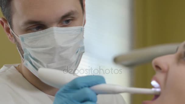 Ο οδοντίατρος εξετάζει το στόμα του ασθενούς με ενδοστοματική κάμερα. — Αρχείο Βίντεο