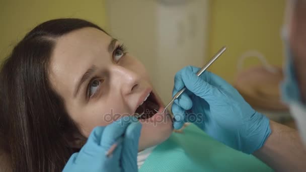 口と歯の検査。患者の若い女の子口腔診査中に口を開けてのクローズ アップ. — ストック動画