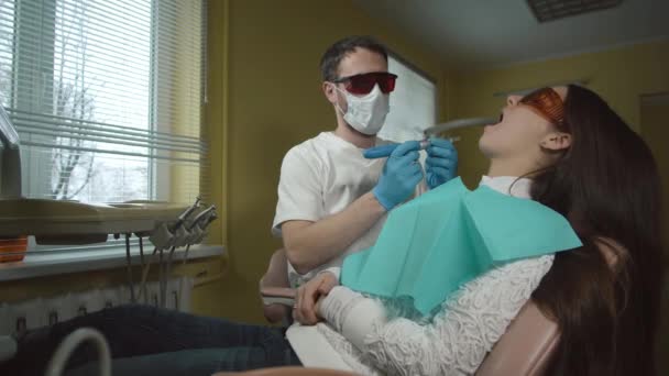 Paziente di sesso femminile che riceve un trattamento con apparecchiature per la luce UV dentale. Studio dentistico . — Video Stock