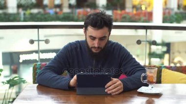 Tablet bilgisayar kafede oturan genç adam