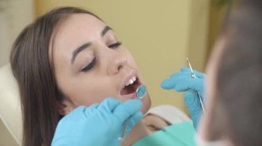 Diş hekimi diş ofiste Bayan hasta inceliyor.