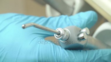 Diş ofisi. Diş hekimi, araçları, tıp aletleri donanımları. El doktor su aracıyla test ediyor. Sağlık kavramı.