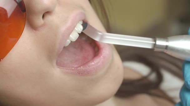 Paziente di sesso femminile che riceve un trattamento con apparecchiature di luce UV dentale — Video Stock