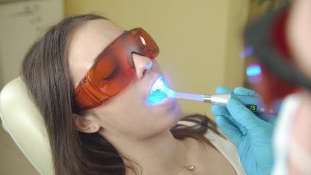 Bayan hasta tedavi diş Uv ışık cihazları ile görüyor. Diş office. — Stok video