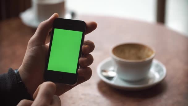 Львів, Україна - 2017 січня: Чоловічої руки за допомогою смартфона з зеленим екраном в кафе. — стокове відео