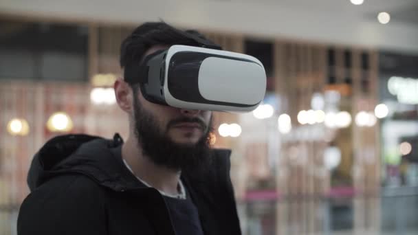 Hombre joven usando gafas de realidad virtual en el centro comercial — Vídeo de stock