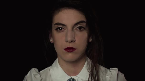 Mujer pinta sus labios con lápiz labial sobre un fondo negro — Vídeos de Stock