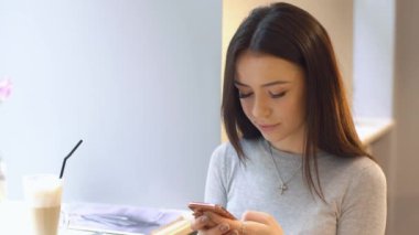 kafede Smartphone kullanan güzel genç kız