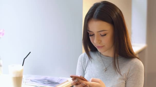 Bella ragazza utilizzando smartphone in caffè — Video Stock