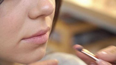 Güzellik Salonu istemcisinin dudaklarında ruj uygulama profesyonel makyaj sanatçısı. Güzellik, son saatlerinde yanında bulunanlar ve moda kavramı. Atış kapatın