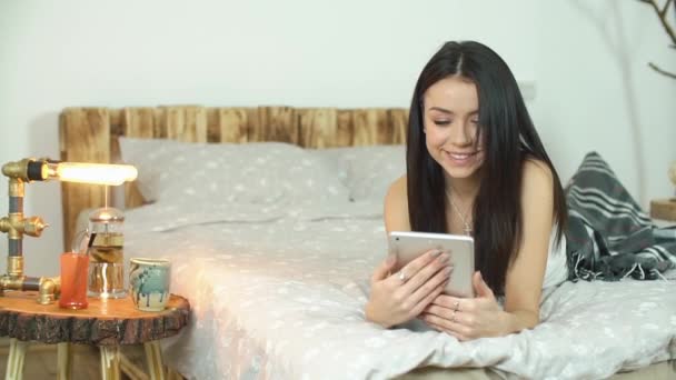 Belle fille utilisant une tablette avec écran vert couché sur le lit à la maison — Video