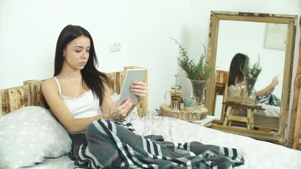 Belle fille utilisant une tablette avec écran vert couché sur le lit à la maison — Video