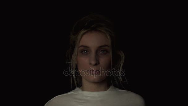 一个精神病患者的年轻女子，在黑色背景下的肖像 — 图库视频影像