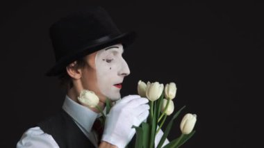 adam MIME bir buket çiçek siyah bir arka plan ile