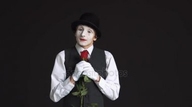 siyah bir arka plan üzerinde kırmızı bir gül ile MIME dostum. O çiçek ve hayalleri bir tarihin bir kadınla burnunu çekmek