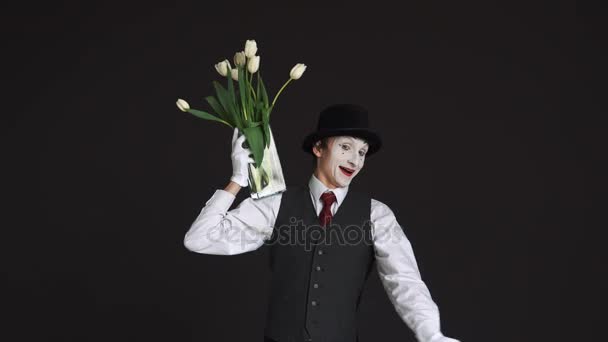 Mímica homem com um buquê de flores em um fundo preto — Vídeo de Stock