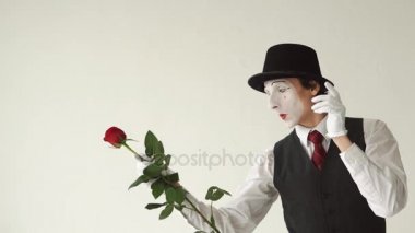 Beyaz zemin üzerine kırmızı bir gül ile MIME dostum. O bir çiçek ile çalış ve birine verir