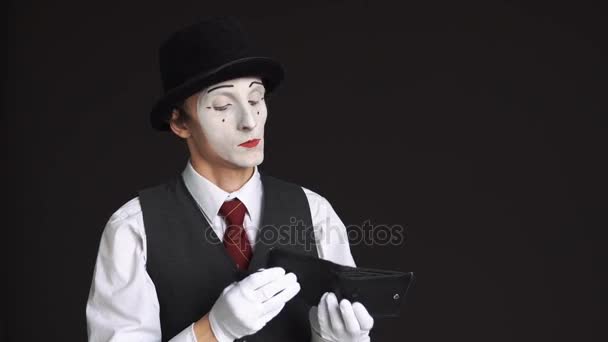 Male MIME looking for money in purse on a black background. A purse is empty, no money. The concept of a poor man who spent all the money — Stock Video