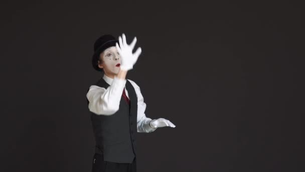 Man mime in virtual reality on a black background. He turns the pages, surfing the Internet — Stock Video