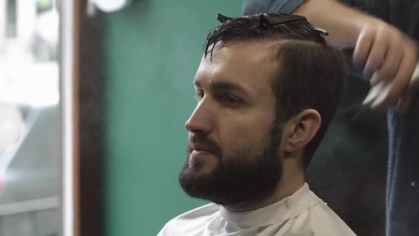 Main masculine avec une brosse balaie les restes de cheveux de la tête, gros plan — Video