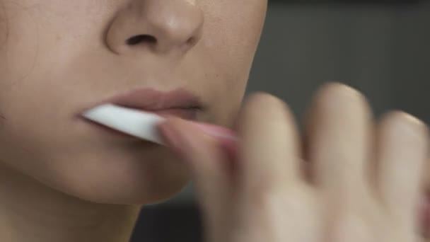 Menina bonita escovar os dentes com uma escova de dentes no banheiro com uma toalha na cabeça. O conceito de autocuidado, procedimentos de banho, close-up — Vídeo de Stock