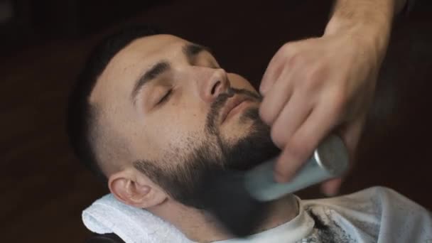Barber shaves the beard of the client in the barbershop — Stock Video