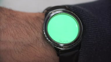 Adam jestleri bir yuvarlak ekran modern smartwatch bir yeşil ekran chroma anahtar içeriği olan üzerinde eller. saati sağ elinde olduğunu