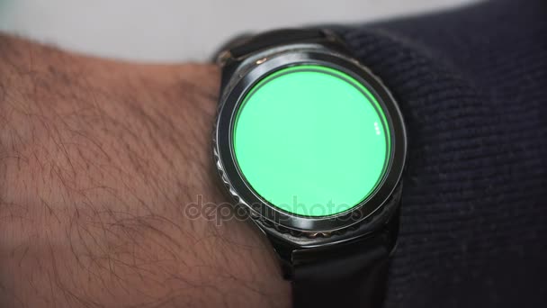 Hombre manos gestos en una pantalla redonda reloj inteligente moderno con un contenido clave croma pantalla verde. el reloj está en su mano derecha — Vídeos de Stock