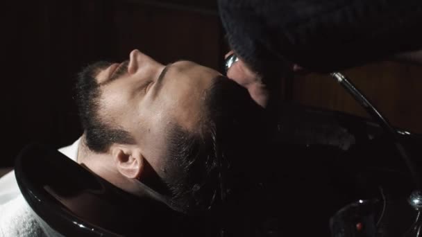 Friseur wäscht Mann Kopf im Friseursalon — Stockvideo