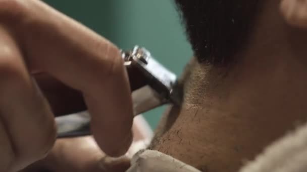Barbero barba de corte a mano con clipper en la barbería. Vídeo de cerca, 4k. Peluquero trabaja con el trimmer eléctrico — Vídeos de Stock