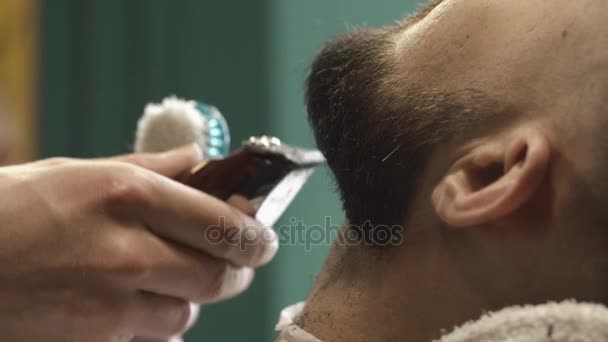 Barbero barba de corte a mano con clipper en la barbería. Vídeo de cerca, 4k. Peluquero trabaja con el trimmer eléctrico — Vídeo de stock