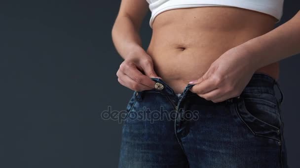 Толстая женщина тело пытается надеть ее узкие джинсы — стоковое видео