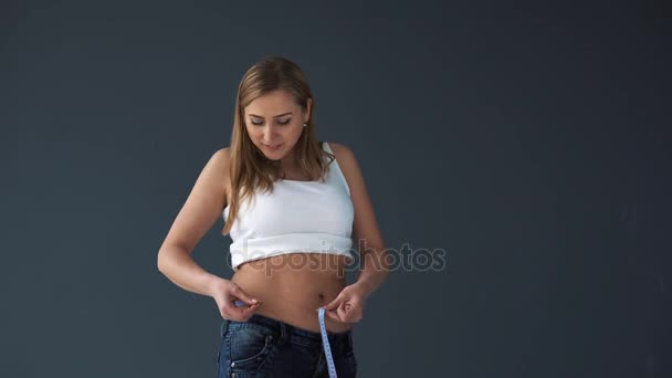 Mulher com excesso de peso medindo a cintura com uma fita métrica. Ela ficou desapontada com sua figura completa — Vídeo de Stock