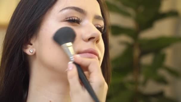 Profesional maquillaje artista aplicación de cosméticos en la cara de linda chica adolescente para el cuidado de la piel y la salud cutis — Vídeos de Stock