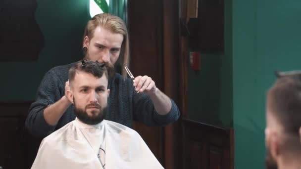 Friseur schneidet Mann im Friseursalon die Haare — Stockvideo