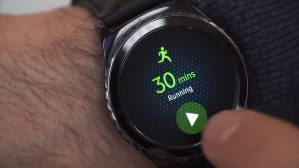 Nahaufnahme einer intelligenten Uhr auf männlicher Hand. Joggen auf dem Display der Smartwatch. Mann bereitet sich auf die Flucht vor. Fitnessübung — Stockvideo