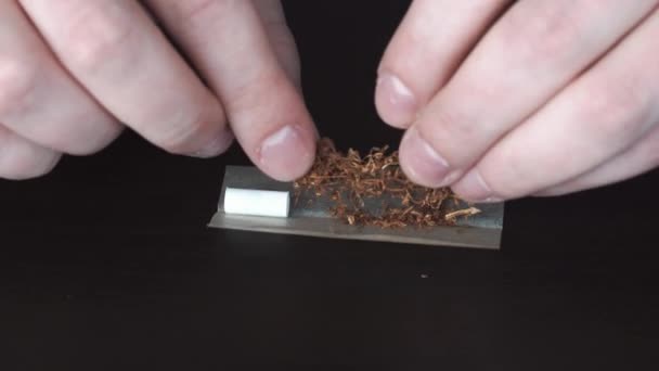 As mãos do jovem estão torcendo cigarros de tabaco. O conceito de jovens fumadores, os perigos do tabaco, close-up — Vídeo de Stock