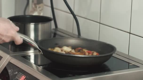 Chef roasting vegetables with mushrooms in a frying pan. Chef prepares vegetarian dishes — Stock Video