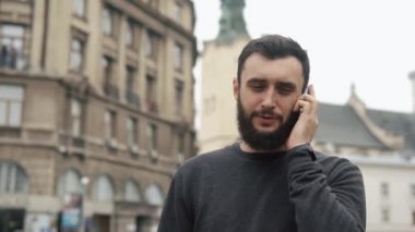 Şehirde yürüyüş onun Smartphone adam görüşmeler bilemek