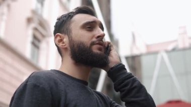 Şehirde yürüyüş onun Smartphone adam görüşmeler