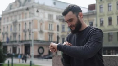 Sakallı adam şehirde bir yerlerde onun akıllı izle ayakta denetler