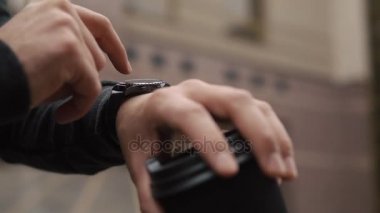Bir fincan kahve ile onun akıllı izle ayakta sakallı adam denetler